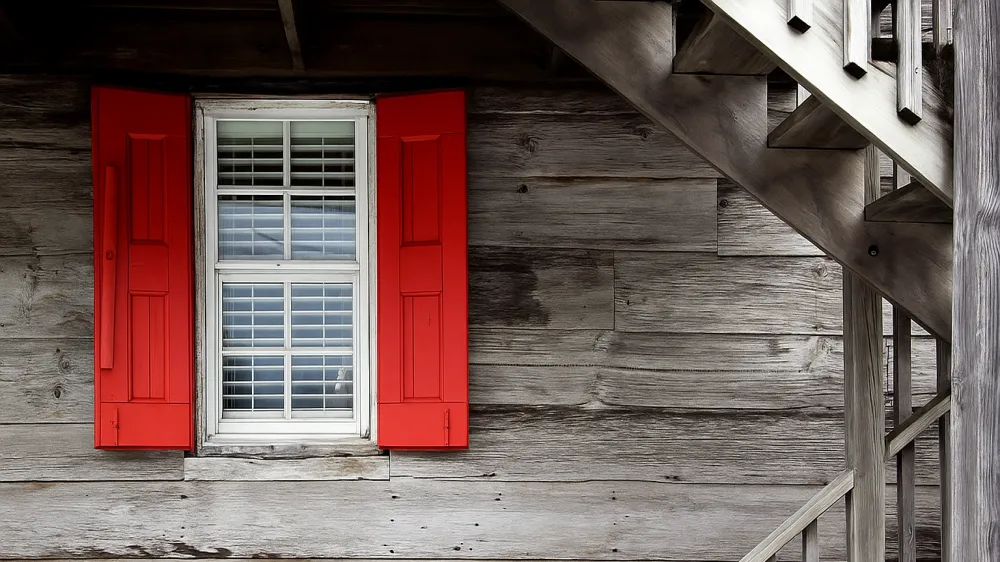 Black and white wood wall and window with red shutters